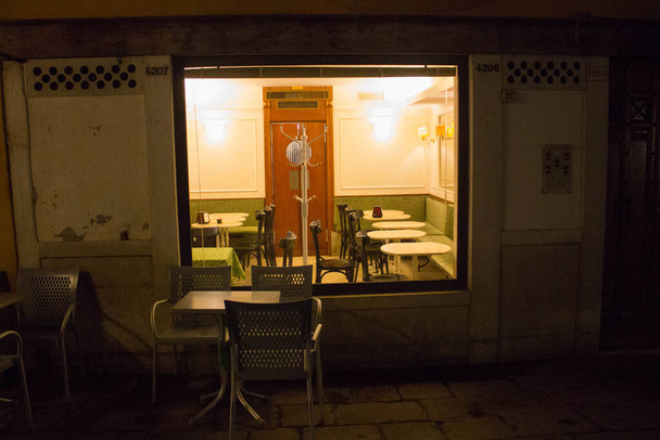 Venice, Italy, January 28, 2020 evocative image of the interior of a coffee shop seen from the outside at night - Φωτογραφία, εικόνα