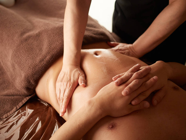 Asian man receiving a stomach massage - Fotoğraf, Görsel