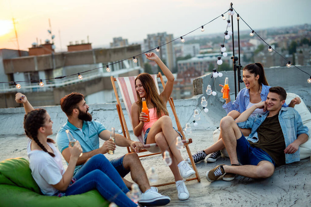 Having a great time with young friends, having fun at rooftop party - Fotoğraf, Görsel