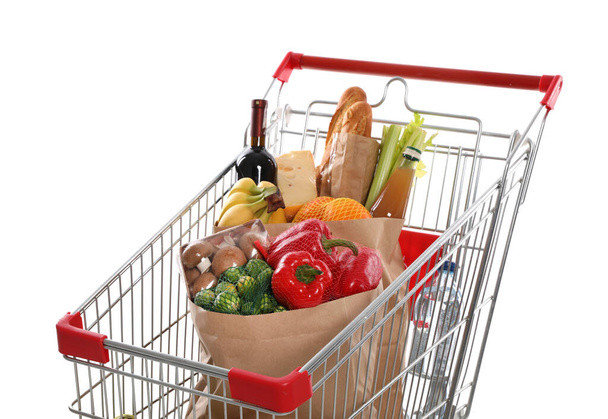 Shopping cart full of groceries on white background - Фото, зображення