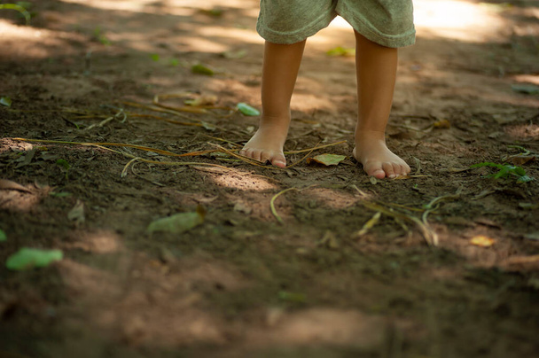 selective focus of children's barefoot on ground  - Foto, imagen