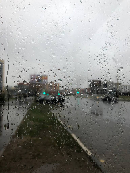 σταγόνες βροχής στο γυαλί. Το τοπίο της πόλης σε μια γκρίζα ζοφερή μέρα - Φωτογραφία, εικόνα
