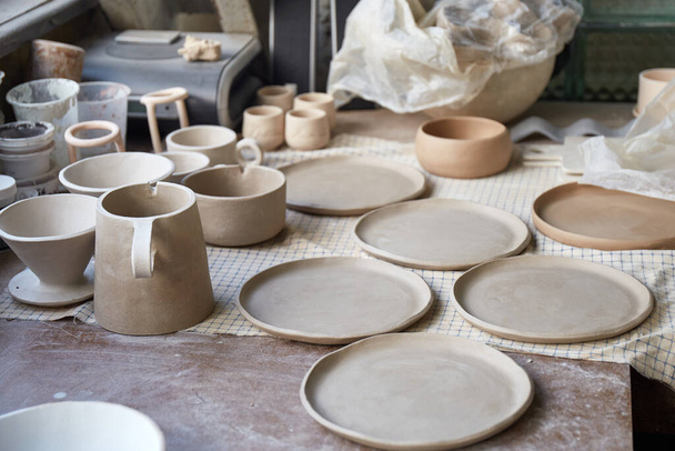 Pottenbakkerij studio Het proces van het maken van aardewerk. De meesterkeramiste werkt in haar atelier. werkplaats van pottenbakker - Foto, afbeelding