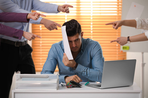 Coworkers bullying their colleague at workplace in office - Photo, Image