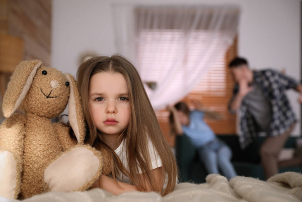 Couple fighting at home, focus on their unhappy little daughter. Domestic violence - 写真・画像