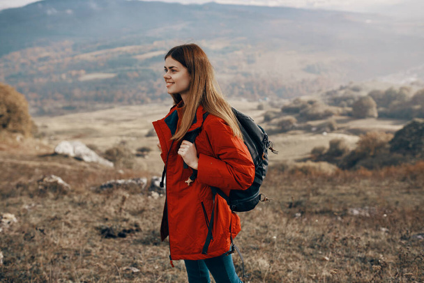 κοκκινομάλλα γυναίκα σε σακάκι με σακίδιο ταξίδια πεζοπορία βουνά φρέσκο αέρα - Φωτογραφία, εικόνα