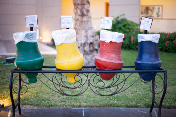Pots en argile de couleurs bleu, rouge, jaune et vert avec tables Papier, Plastique, Métal, Verre. Tri des ordures dans un hôtel d'Egypte.  - Photo, image
