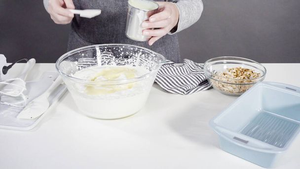 Mezclar los ingredientes en un tazón de vidrio para preparar helado de coco casero. - Foto, imagen
