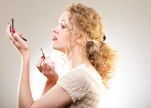 Pretty woman applying make-up with powder - Фото, зображення