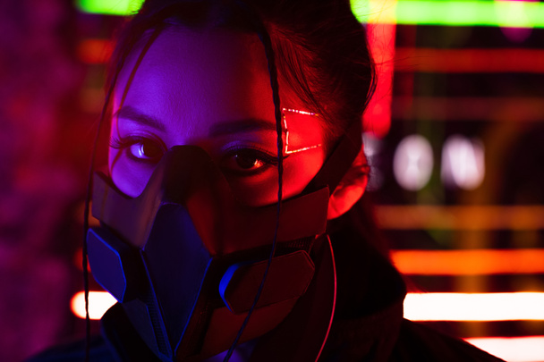 молода азіатська жінка в чорній газовій масці дивиться на камеру
 - Фото, зображення