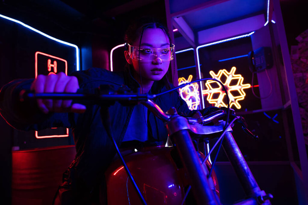 young asian woman in sunglasses riding motorcycle outside  - Photo, Image