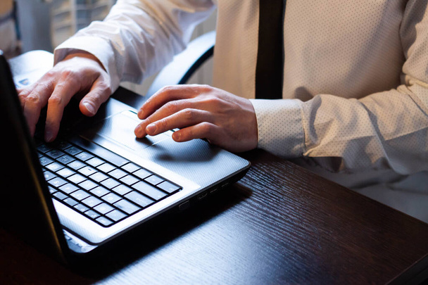 Üzletember fehér ingben és fekete nyakkendőben otthon dolgozik a számítógépnél. - Fotó, kép