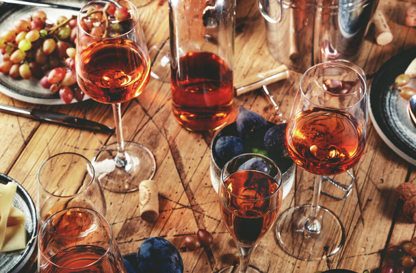 Rose rose verres à vin et bouteilles sur la table servi pour le dîner de fête d'été avec différents types d'entrées  - Photo, image
