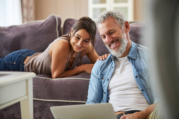 Delighted bearded man looking at screen of laptop - Photo, Image