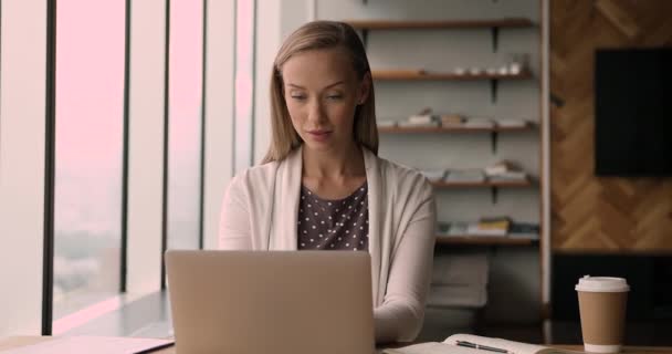 Young office employee work on laptop, taking notes, do paperwork - Filmagem, Vídeo