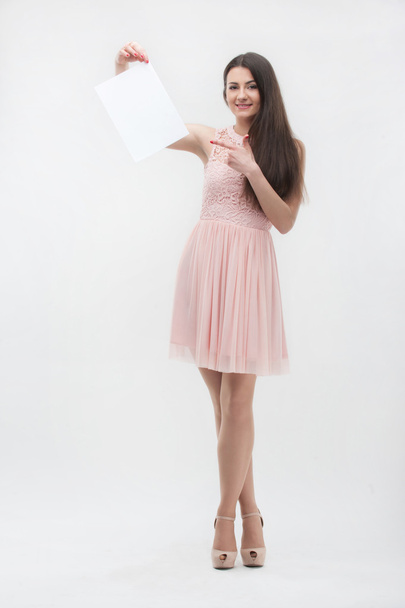 Woman in pink dress pointing on place copy - Фото, изображение