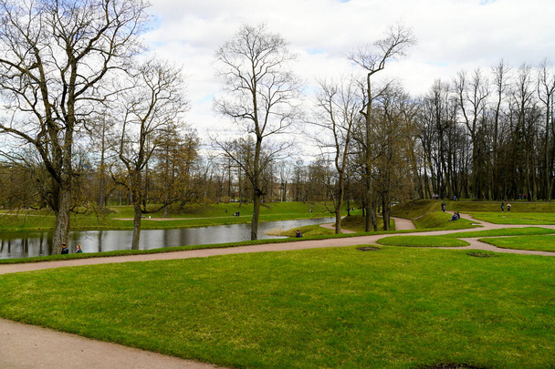 Пейзаж парка с рекой и прогуливающимися людьми - Фото, изображение