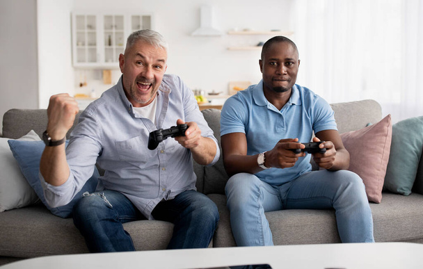 Who wins. Video console, friends playing, having fun together at home - Foto, imagen