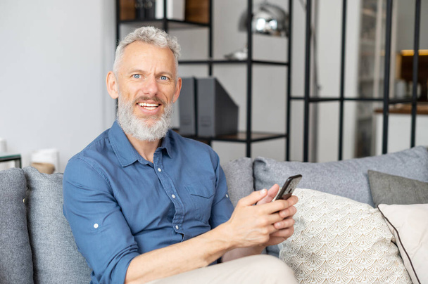 Middle aged bearded man using smartphone - Zdjęcie, obraz
