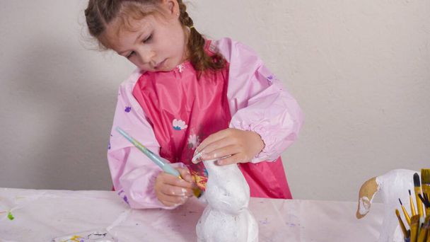 Маленька дівчинка малює папір фігурка на уроці домашнього мистецтва
. - Фото, зображення