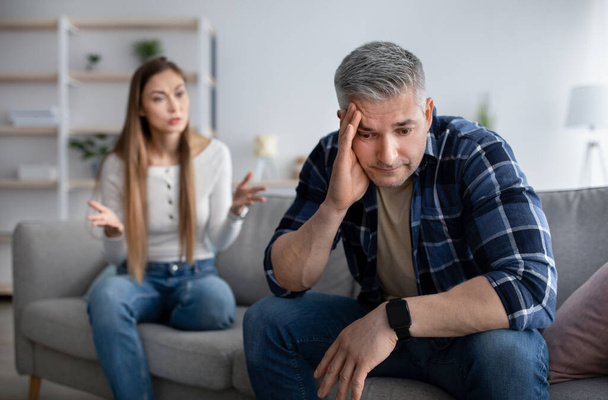 Angry mature woman shouting at her upset husband, having conflict at home, copy space - Photo, Image