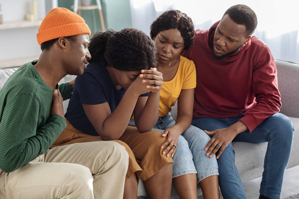 Supportive amis noirs consolant leur petite amie pleurant - Photo, image