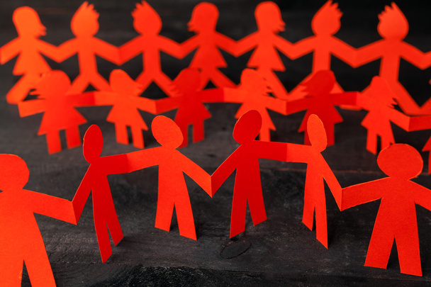 Team of paper doll people holding hands - Foto, afbeelding