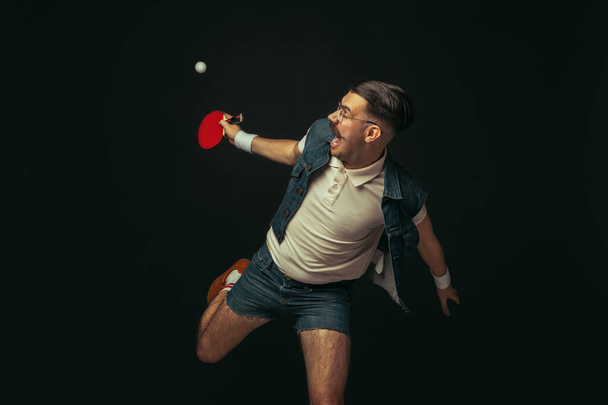 Young caucasian man playing tennis isolated on black studio background in retro style, action and motion concept - Photo, image
