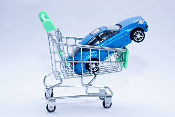 Μπλε επιβατικό αυτοκίνητο σε ένα καλάθι αγορών. Ιδανική στιγμή για να αγοράσετε ένα νέο αυτοκίνητο ή αξεσουάρ αυτοκινήτων. - Φωτογραφία, εικόνα
