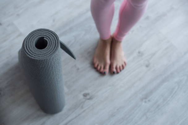 selective focus of yoga mat near barefoot woman, cropped view - Photo, image