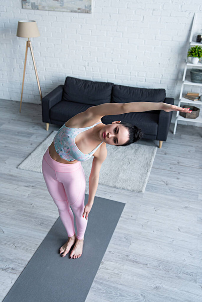 високий кут зору спортивна жінка стоїть в боковій позі вигину під час практики йоги
 - Фото, зображення