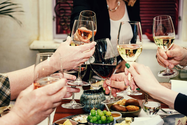A table in a restaurant. Dinner with wine. Bacon salad. Buns. Table setting. Holiday. Glasses in hand. - Photo, Image