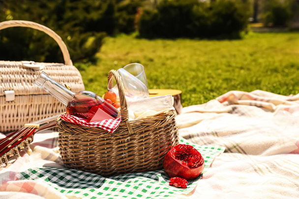 Leckeres Essen und Wein in Picknickkorb auf Decke im Freien. Raum für Text - Foto, Bild