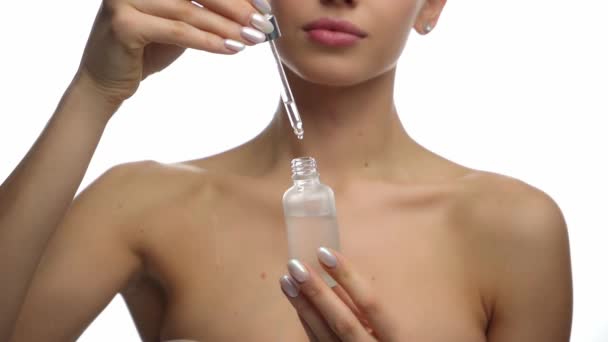 vue recadrée de la jeune femme appliquant sérum hydratant isolé sur blanc - Séquence, vidéo
