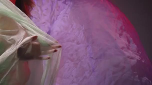 紫と赤の上にシフォンのドレープに触れる若い女性に点滅する照明 - 映像、動画