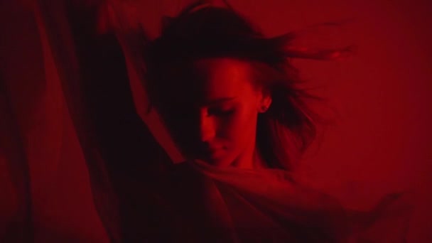 mujer joven cerca de gasa cortina en rojo - Metraje, vídeo