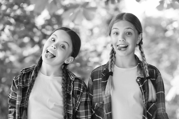 day full of fun. carefree kids posing outdoor. Positive models. Casual hipsters outfit. portrait of happy sisters. funny kids girls in shirt. Two young smiling hipster girls in trendy summer clothes - Foto, immagini