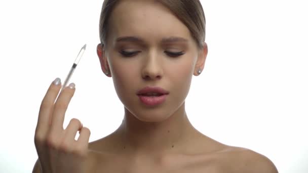 mujer pensativa con hombros desnudos haciendo inyección de belleza en blanco  - Metraje, vídeo