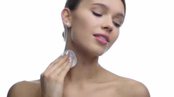 felice donna pulizia collo con batuffolo di cotone isolato su bianco  - Filmati, video