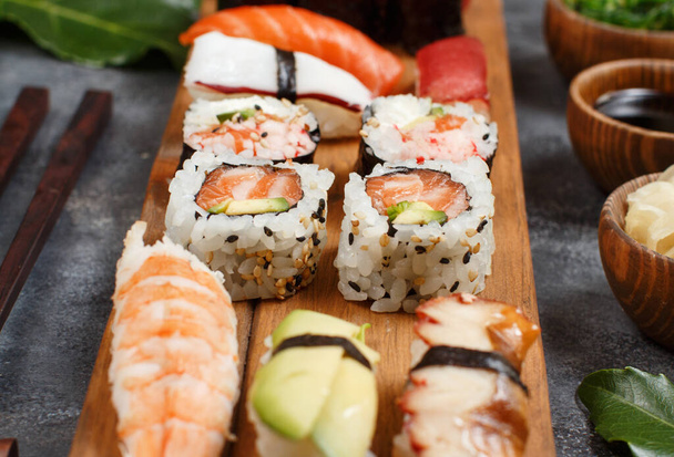 Sushi Set nigiri e sushi rola em uma bandeja de madeira de perto - Foto, Imagem