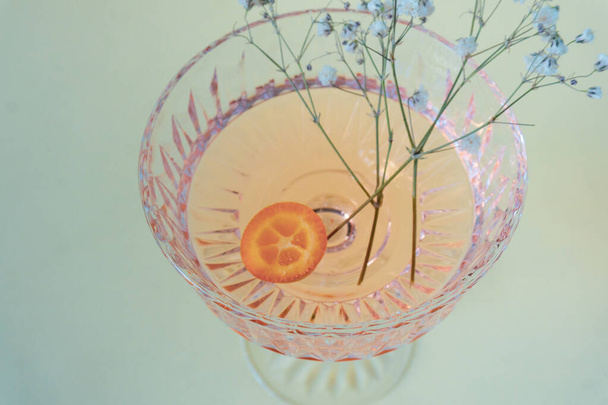 Glass wine glass with pink lemonade and a slice of kumquat. - Foto, Bild