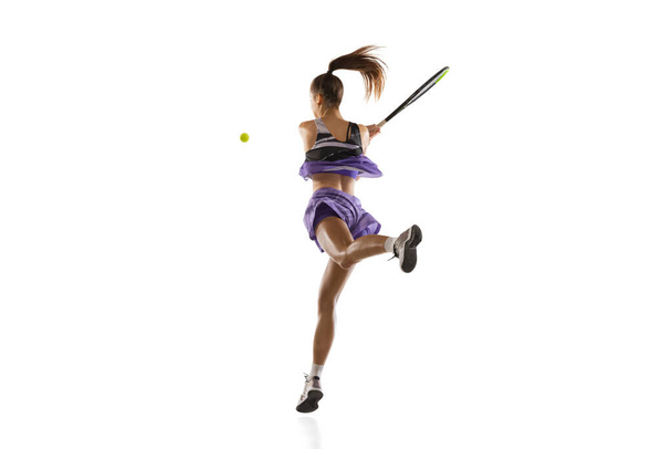 Giovane donna caucasica che gioca a tennis isolato su sfondo bianco studio in azione e movimento, concetto di sport - Foto, immagini