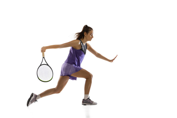 Young caucasian woman playing tennis isolated on white studio background in action and motion, sport concept - 写真・画像