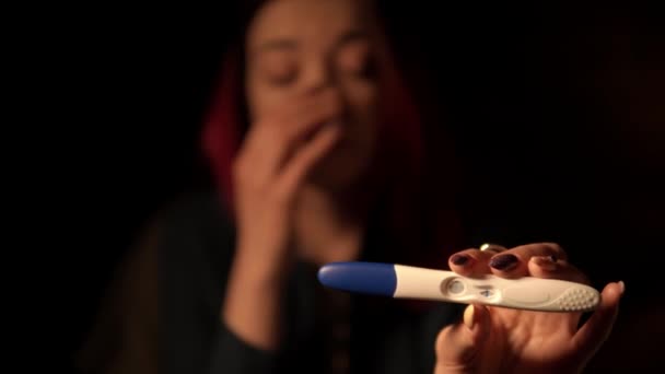 Makroaufnahmen von Frau, die positiven Schwangerschaftstest zeigt und im Hintergrund weint - Filmmaterial, Video