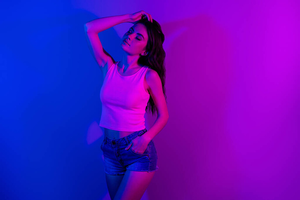 Photo of young stunning elegant gorgeous woman posing dreaming with closed eyes isolated on vibrant neon background - Фото, изображение