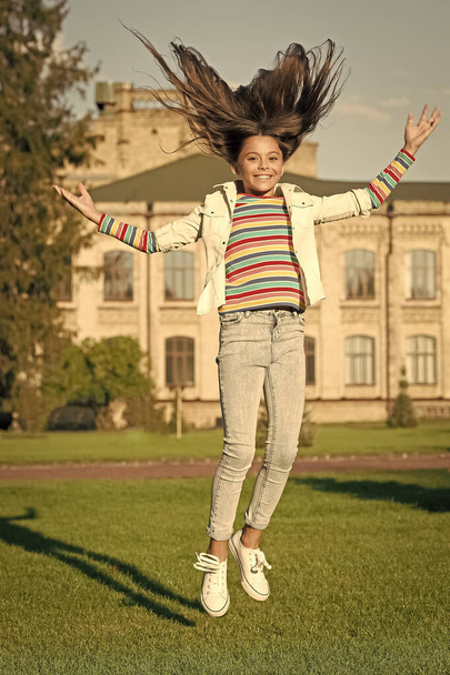 being carefree. full of energy. activity for kids. happy kid jumping and feel free. childhood happiness. small girl with curly hair jump outdoor. spring holiday celebration. child fly in motion - Φωτογραφία, εικόνα
