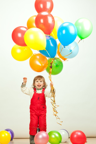 Little girl in red jumping with balloons - Фото, изображение