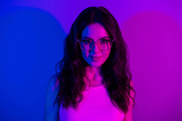 Photo of young attractive girl happy positive smile neon lights wear glasses party isolated over vivid color background - Fotoğraf, Görsel
