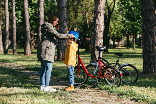 mother and child preparing to ride a bikes in public park - Fotografie, Obrázek