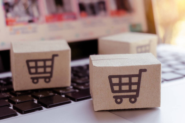 Online-Shopping. Karton mit einem Warenkorb-Logo auf der Laptop-Tastatur. Shopping-Service im Internet. bietet Lieferung nach Hause - Foto, Bild